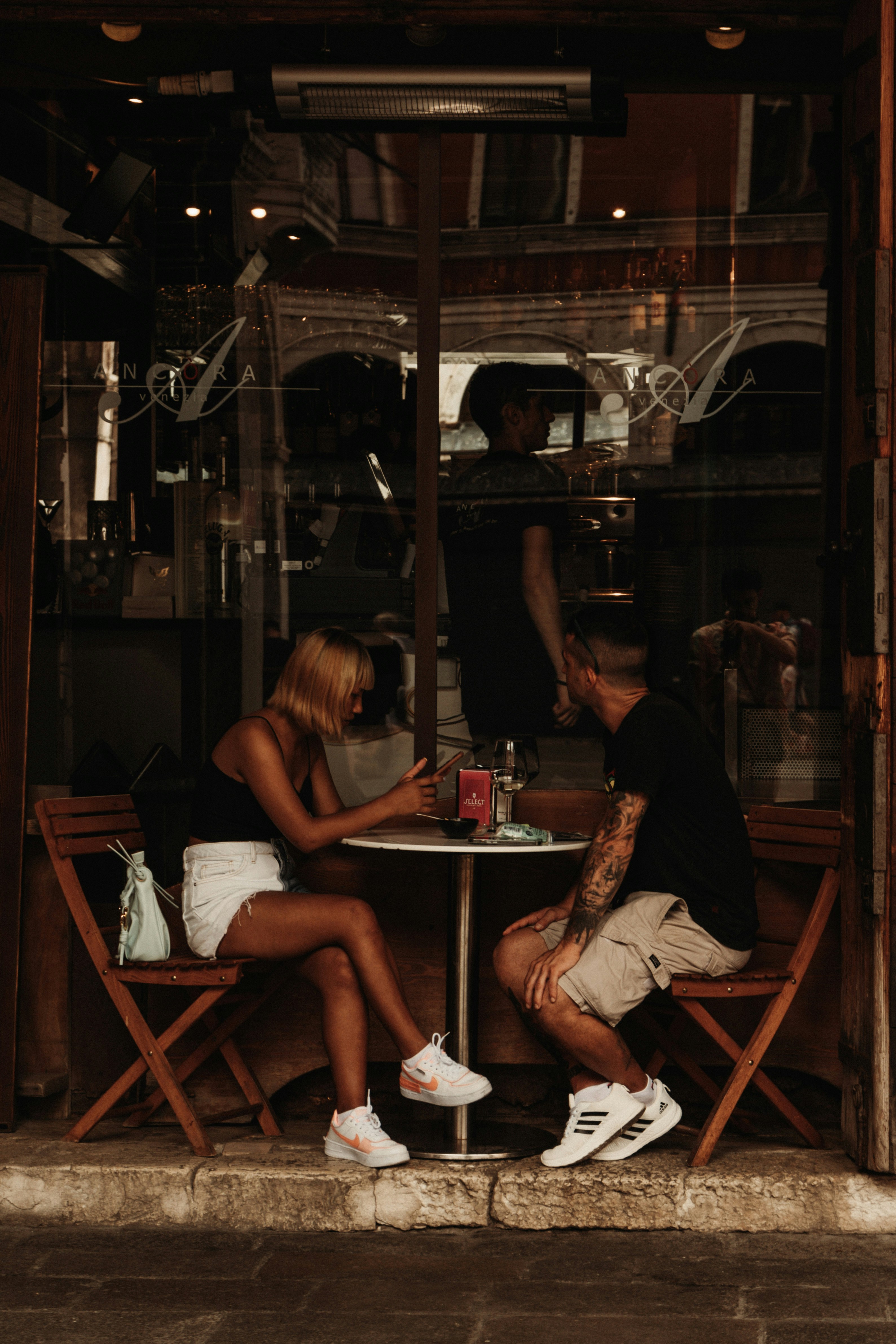 Two people sitting on a sofa having a respectful conversation with distance between them