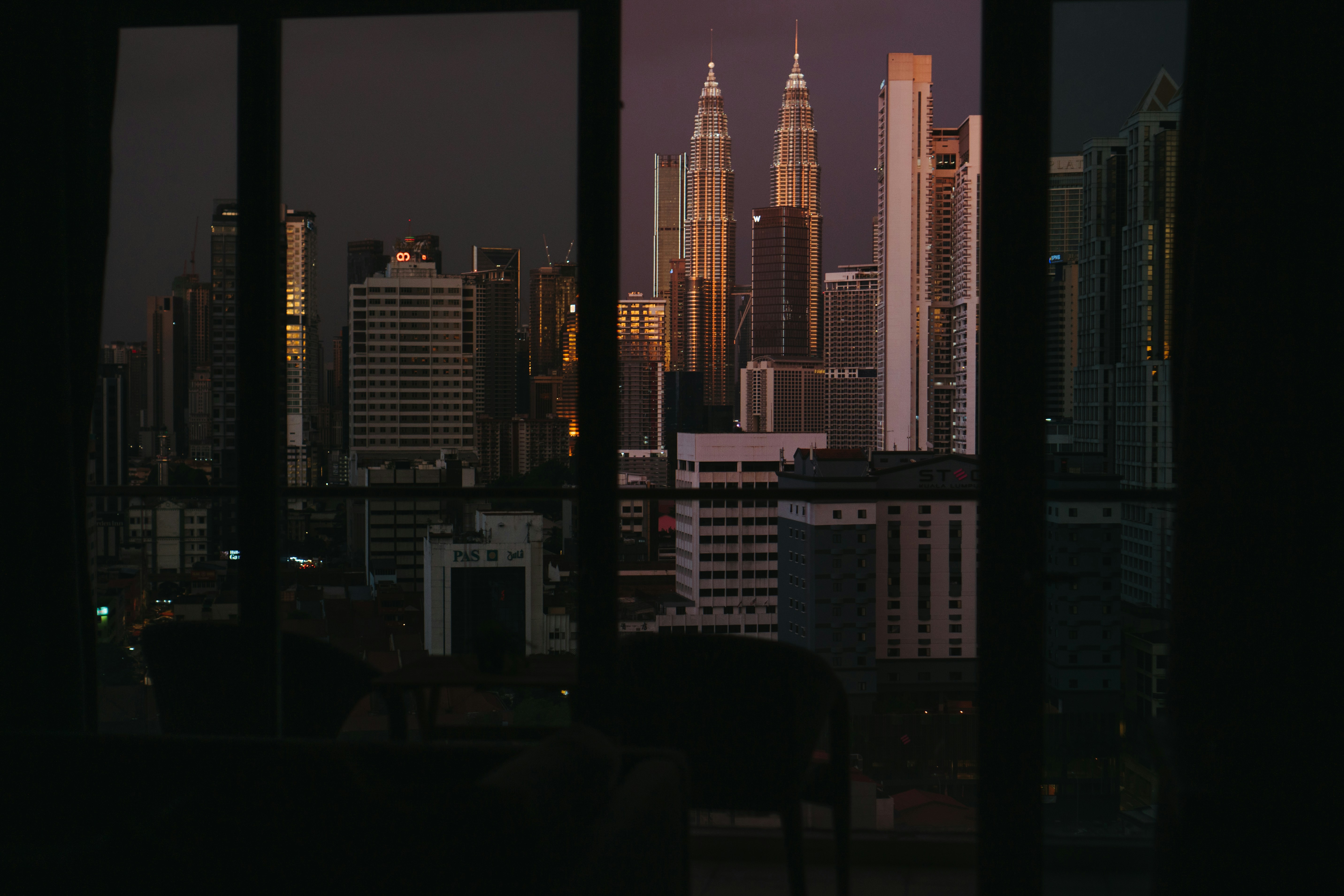 A luxury hotel suite bedroom with city views at night