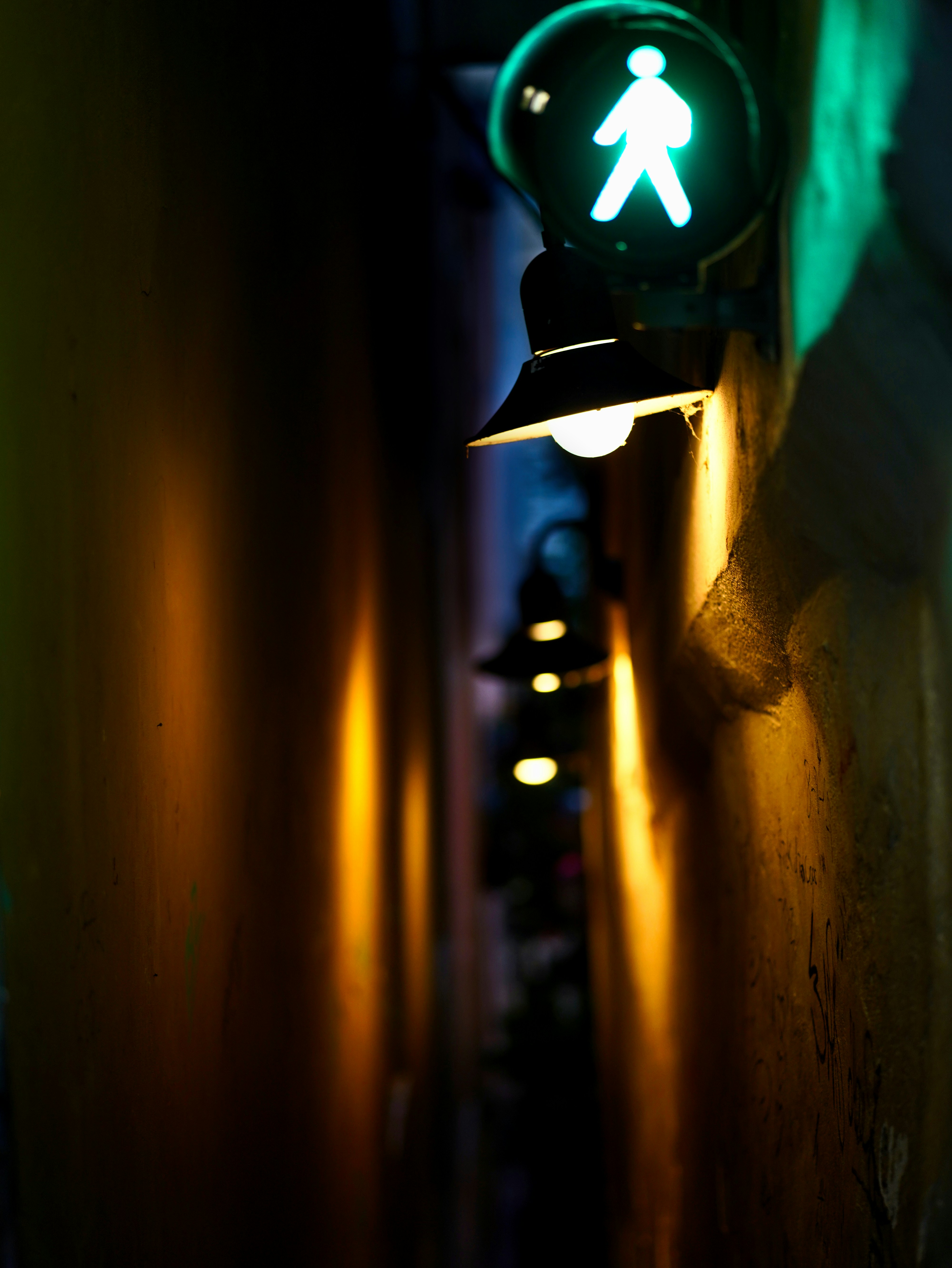 A hand reaching for a door handle in a dimly lit corridor