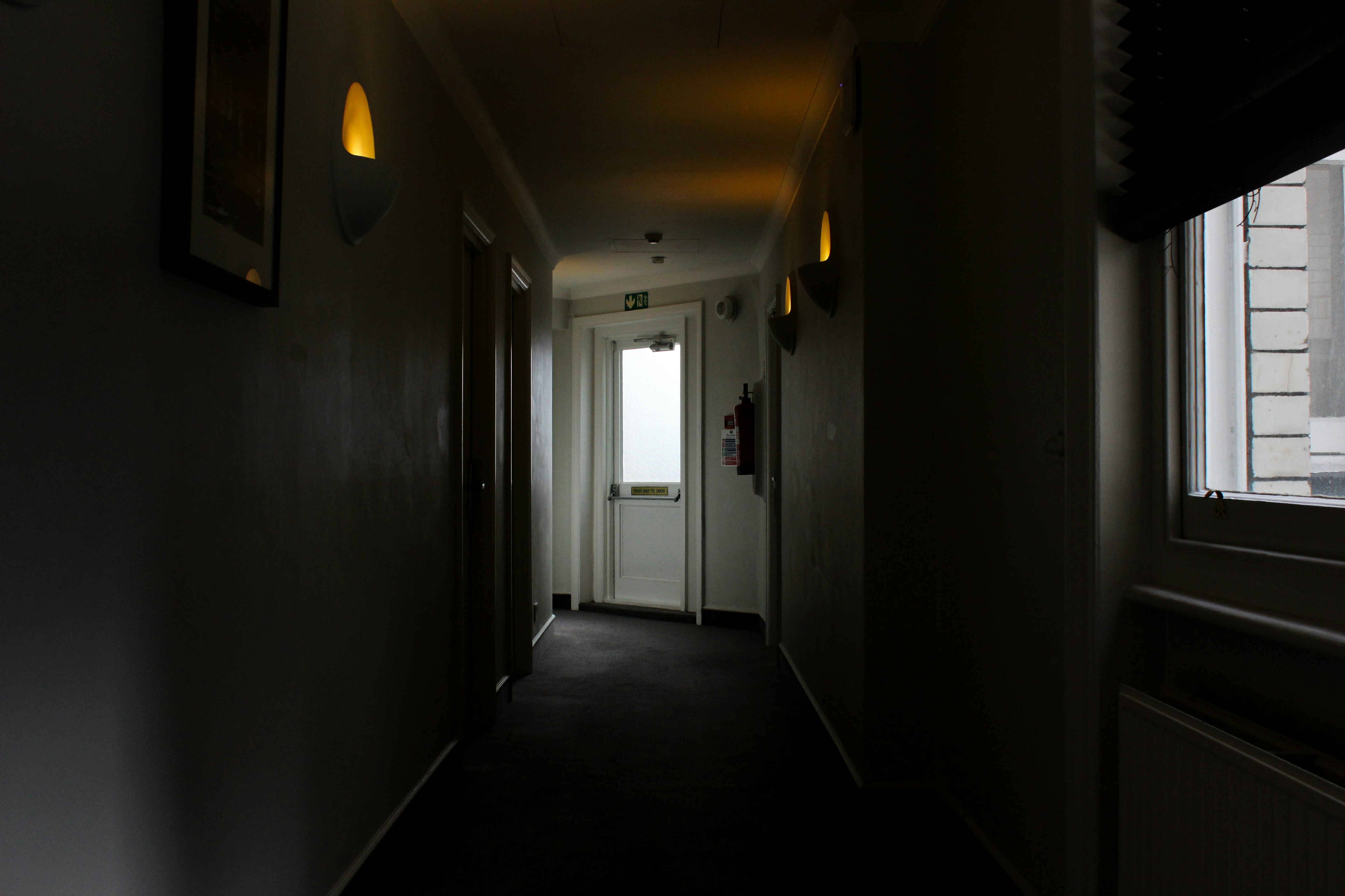 A view from a hotel peephole looking out into a hallway