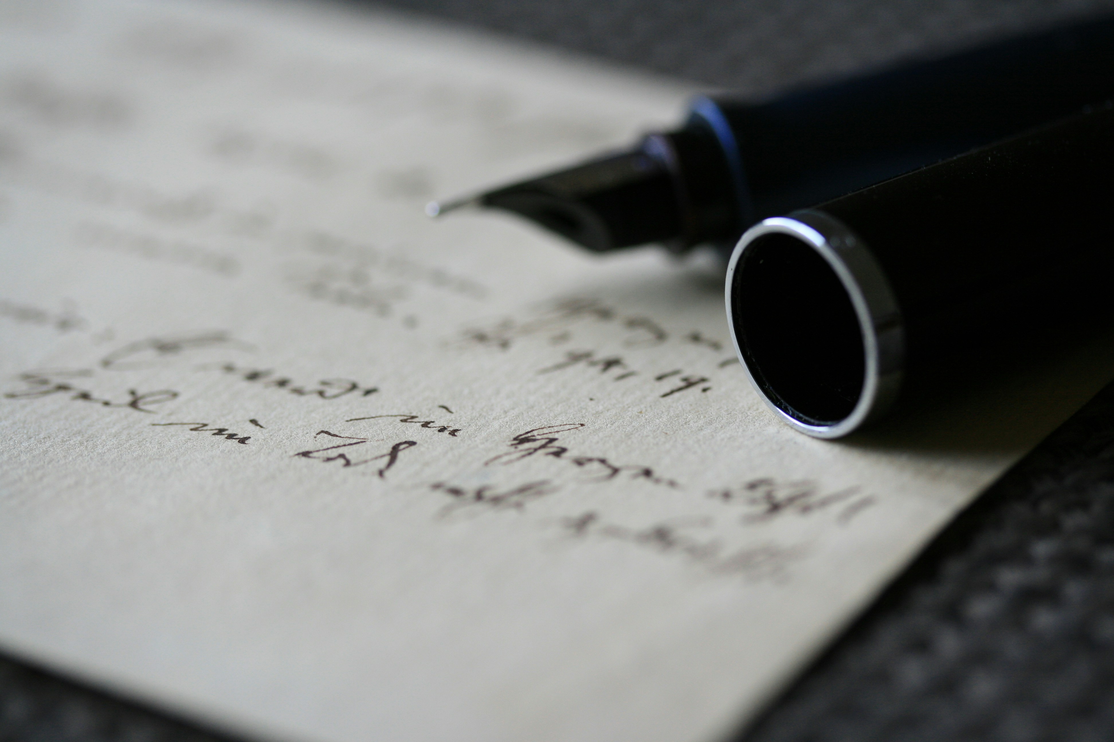 A fountain pen resting on a handwritten note