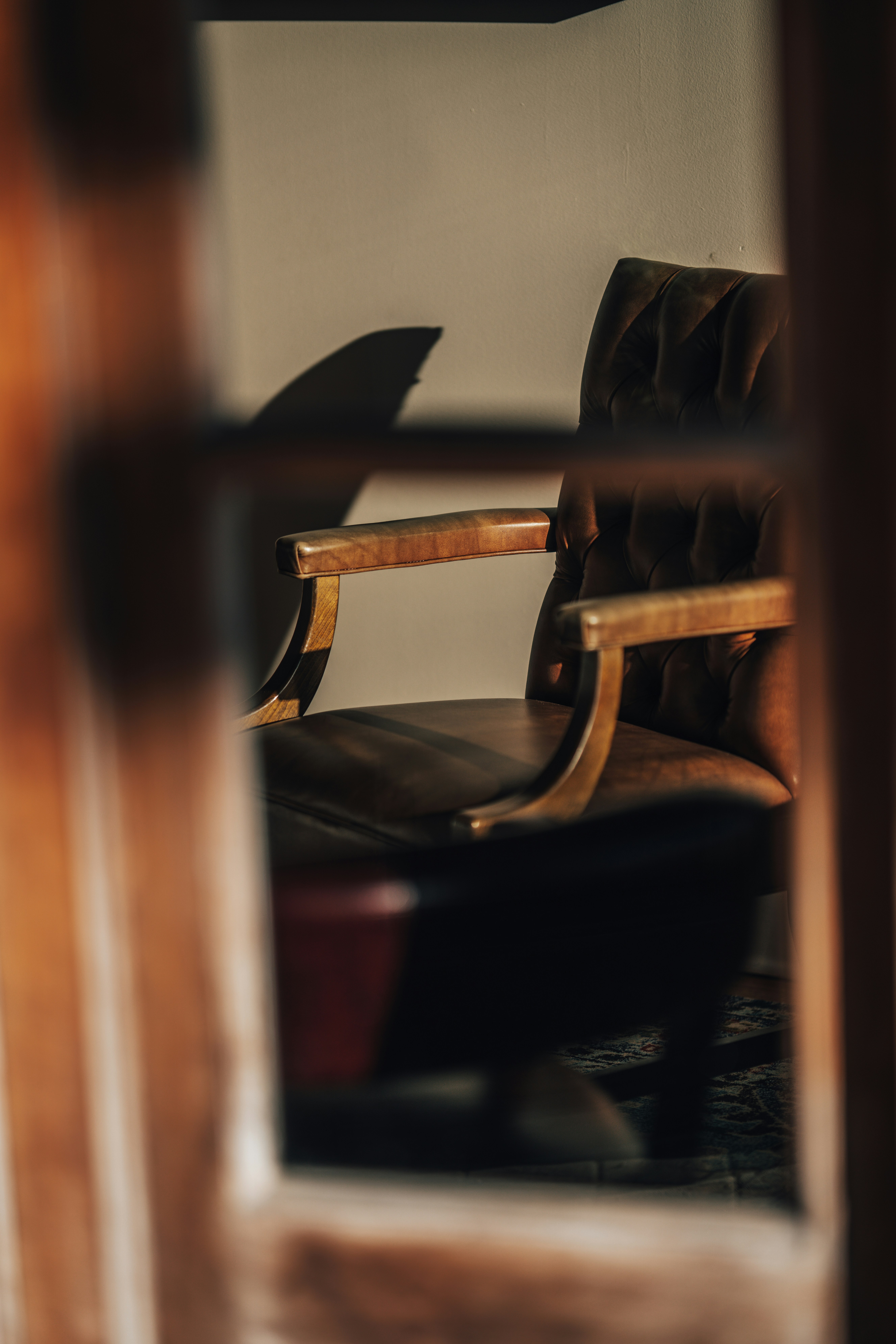 A man checking a classic wristwatch while sitting in a leather armchair