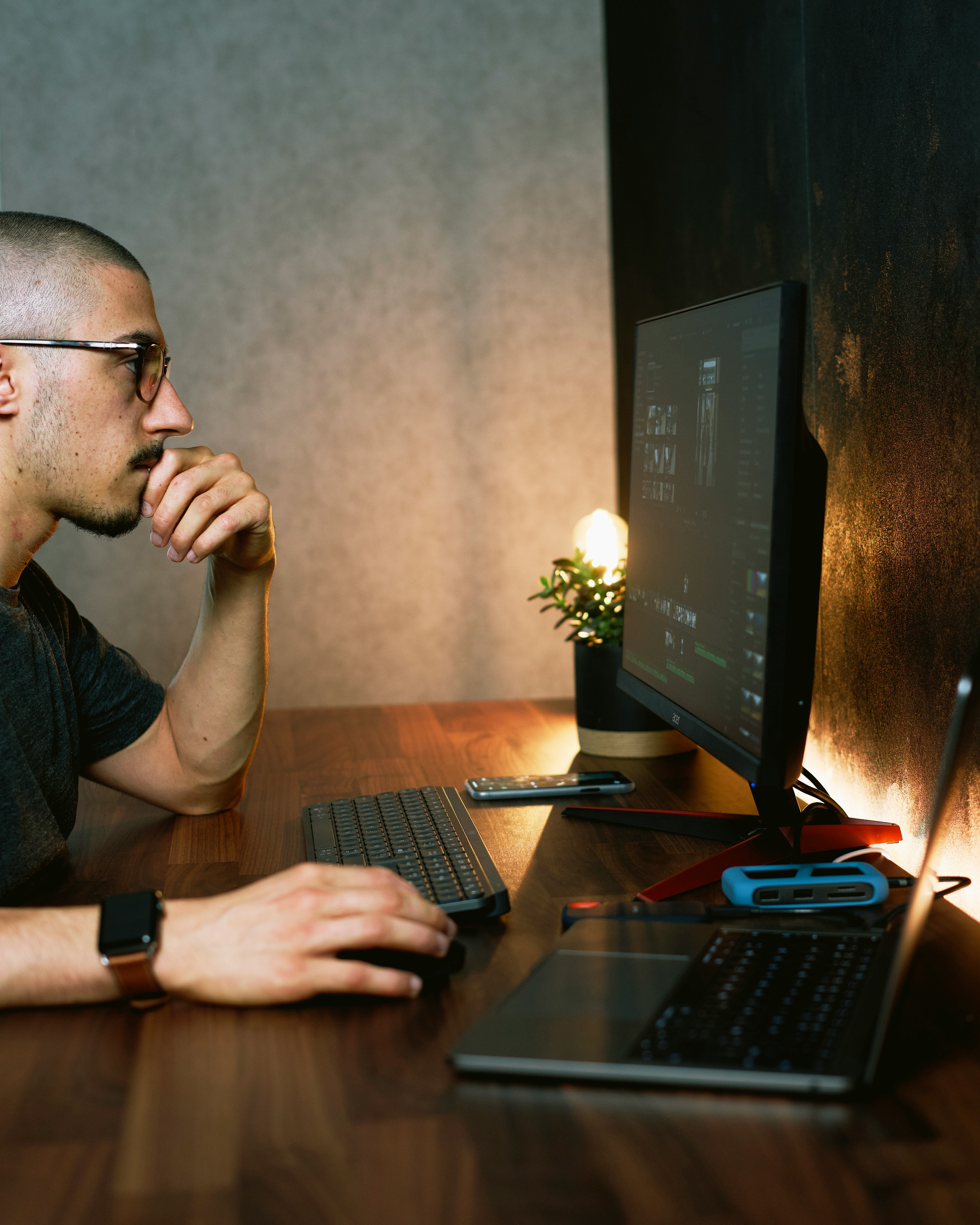 A sophisticated man analyzing a profile on a laptop in a modern home office